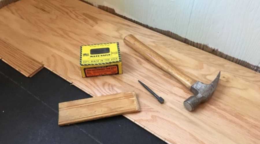 Using hammer and nails for installing laminate flooring
